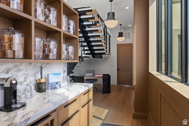 4554 N Forestdale Dr Unit A1, Park City, UT 84098 - interior space with visible vents, open shelves, tasteful backsplash, light stone counters, and light wood finished floors