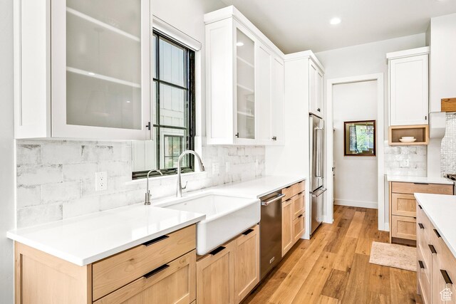522 N Farmhouse Way, Midway, UT 84049 - kitchen featuring decorative backsplash, appliances with stainless steel finishes, a sink, light wood-style floors, and light brown cabinets