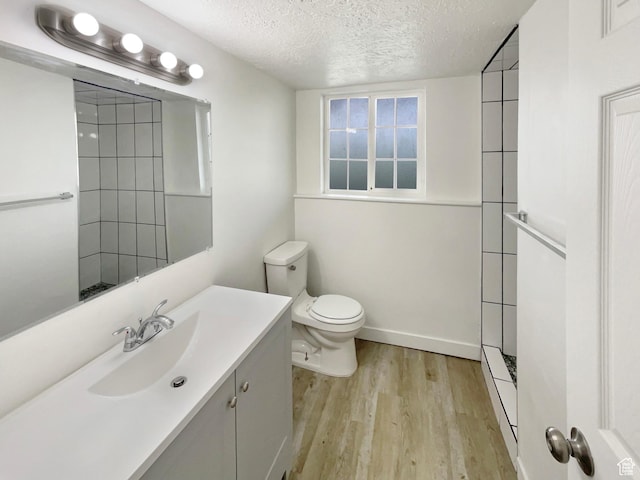 722 E 1300 N, Ogden, UT 84404 - bathroom featuring a textured ceiling, wood finished floors, vanity, toilet, and tiled shower