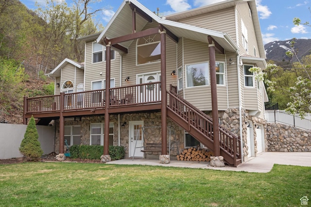 3841 E Grindstone Dr S, Springville, UT 84663 - rear view of property featuring driveway, a yard, a deck with mountain view, an attached garage, and stone siding