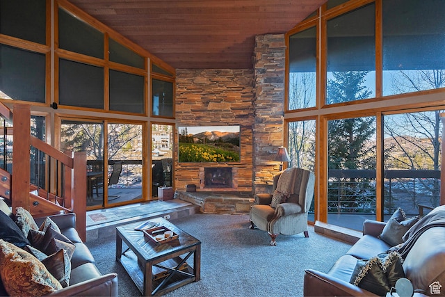 living room featuring carpet floors, wood ceiling, a fireplace, and stairway