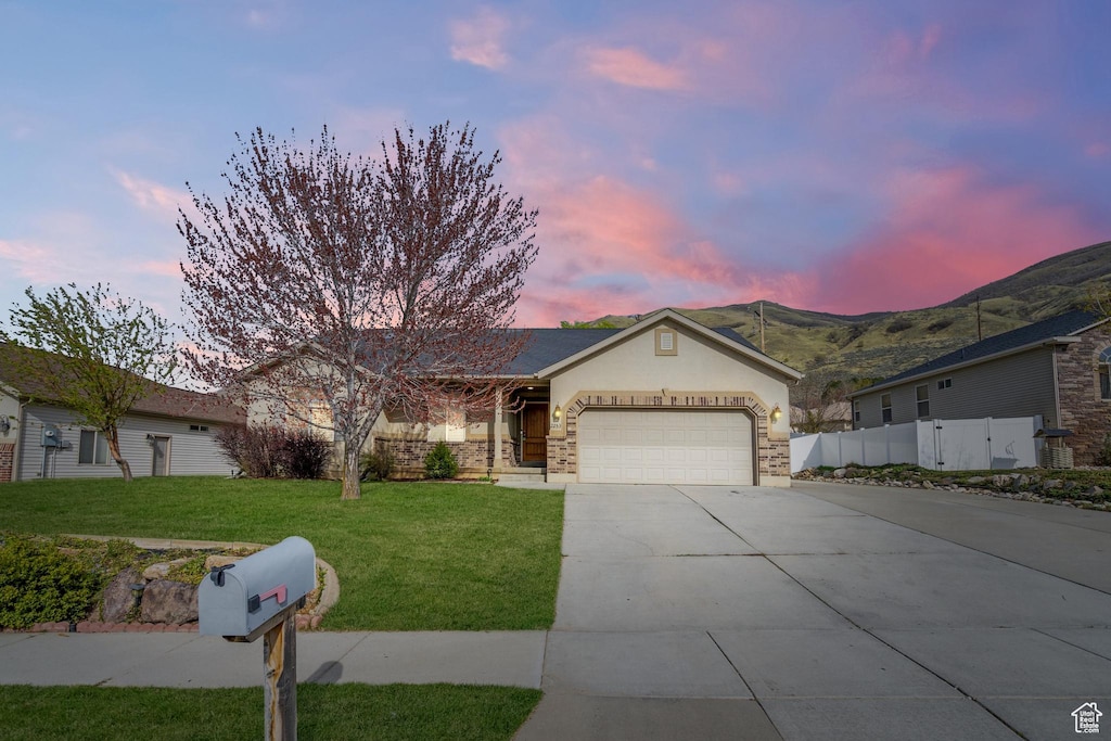 2253 S 385 W, Perry, UT 84302 - ranch-style house featuring fence, an attached garage, a mountain view, concrete driveway, and a yard