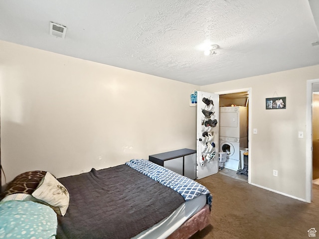 1357 S Lorl Ln # 2, Ogden, UT 84404 - bedroom with visible vents, stacked washer and dryer, baseboards, a textured ceiling, and carpet flooring