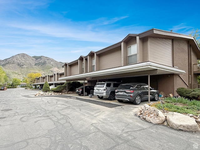 1357 S Lorl Ln # 2, Ogden, UT 84404 - view of side of home with covered parking, a mountain view, and brick siding