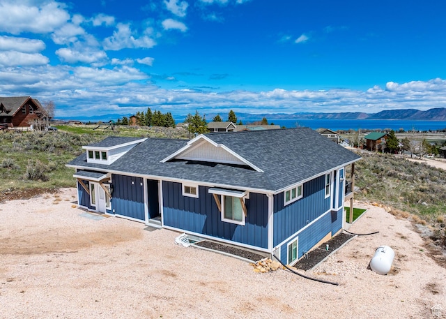 2774 S Chukar Dr, Garden City, UT 84028 - farmhouse-style home with roof with shingles, a mountain view, and board and batten siding