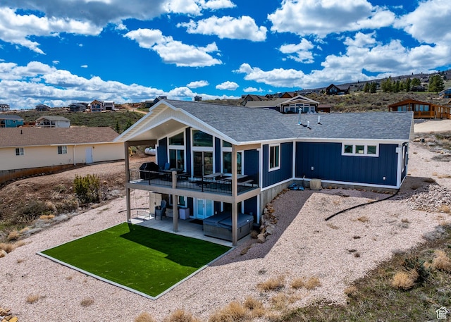 2774 S Chukar Dr, Garden City, UT 84028 - rear view of house featuring a lawn, a shingled roof, and a patio area