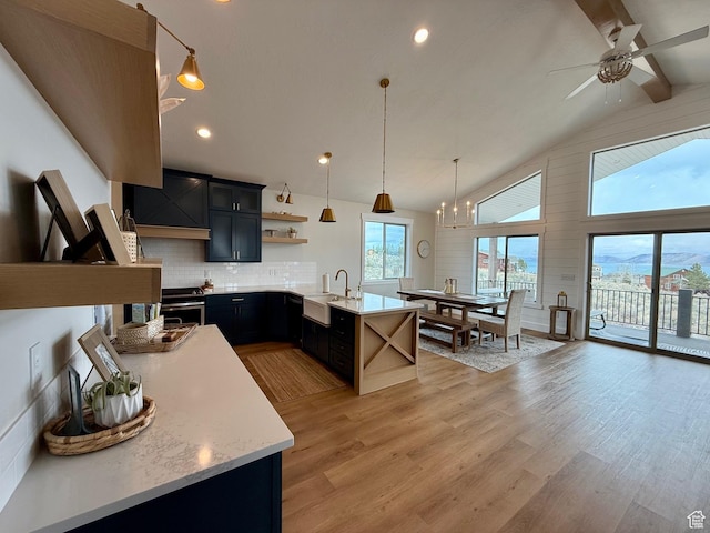 2774 S Chukar Dr, Garden City, UT 84028 - kitchen featuring open shelves, a peninsula, light countertops, a sink, and ceiling fan with notable chandelier