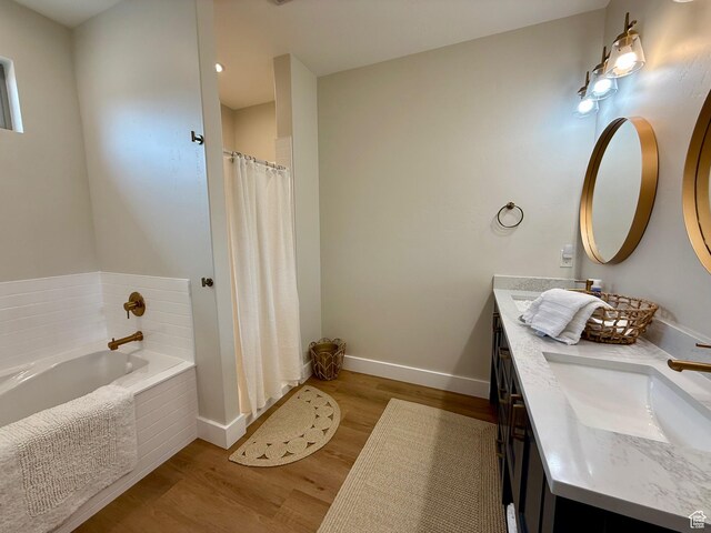 2774 S Chukar Dr, Garden City, UT 84028 - bathroom with double vanity, baseboards, a bath, and wood finished floors
