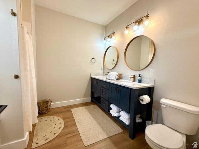 2774 S Chukar Dr, Garden City, UT 84028 - full bath with double vanity, a sink, wood finished floors, and toilet