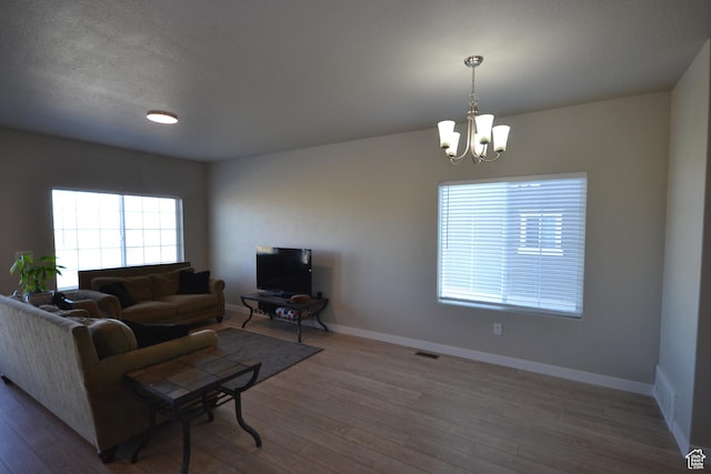 5745 N Gray Hawk Dr, Stansbury Park, UT 84074 - living room with a chandelier, wood finished floors, and baseboards