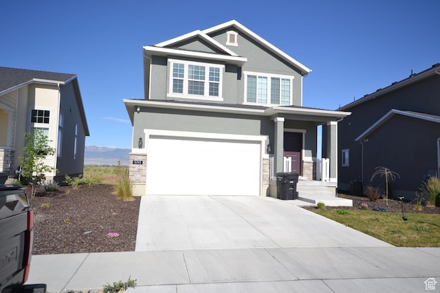 5745 N Gray Hawk Dr, Stansbury Park, UT 84074 - view of front of house with stucco siding, an attached garage, driveway, and stone siding