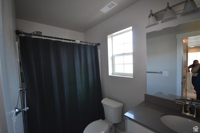 5745 N Gray Hawk Dr, Stansbury Park, UT 84074 - full bath featuring toilet, vanity, plenty of natural light, and curtained shower