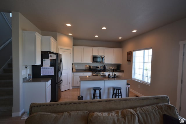 5745 N Gray Hawk Dr, Stansbury Park, UT 84074 - kitchen with appliances with stainless steel finishes, a sink, dark countertops, recessed lighting, and light wood-style floors