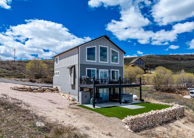 660 N Cambry Dr, Garden City, UT 84028 - back of property with a jacuzzi, a wooden deck, board and batten siding, and a patio