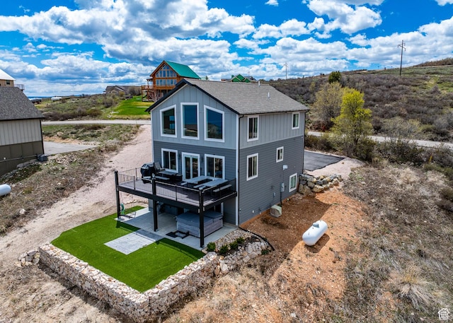 660 N Cambry Dr, Garden City, UT 84028 - rear view of property with a wooden deck, a shingled roof, a patio area, board and batten siding, and a yard