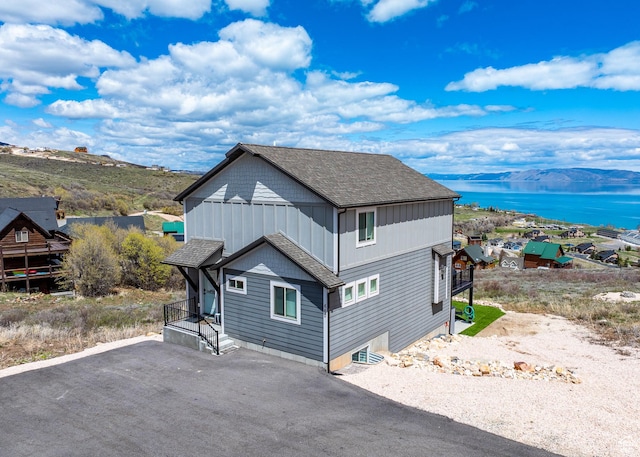 660 N Cambry Dr, Garden City, UT 84028 - view of property exterior featuring driveway, roof with shingles, and a water and mountain view