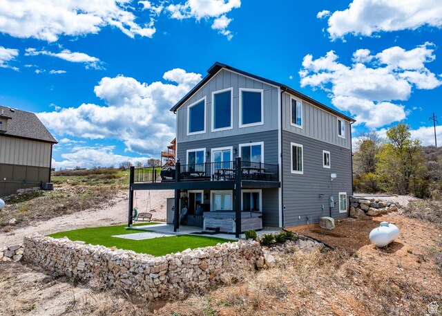 660 N Cambry Dr, Garden City, UT 84028 - back of property with a jacuzzi, board and batten siding, a patio area, and a deck