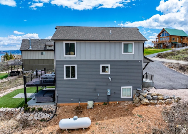 660 N Cambry Dr, Garden City, UT 84028 - rear view of property featuring a shingled roof, board and batten siding, a patio area, and a deck
