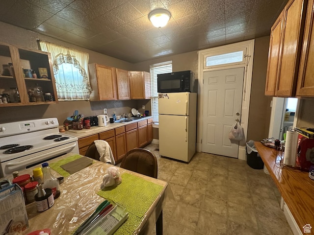 658 23rd St Unit 1, Ogden, UT 84401 - kitchen with brown cabinetry, light countertops, a sink, and white appliances