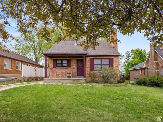 1417 E Binford St, Ogden, UT 84401 - bungalow-style home with covered porch, a chimney, brick siding, fence, and a front lawn