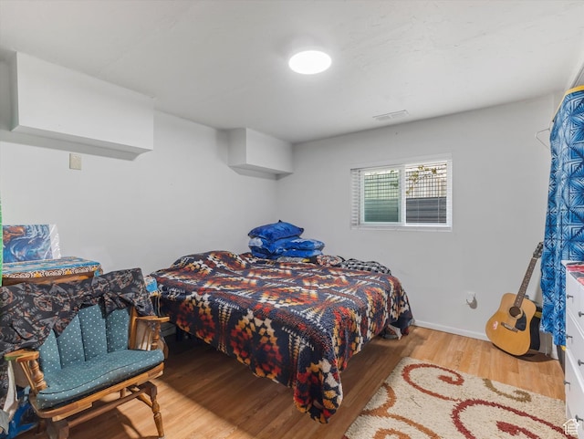 bedroom featuring wood finished floors and visible vents