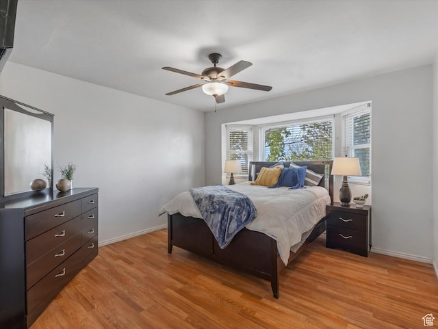 bedroom with light wood-style floors, baseboards, and a ceiling fan
