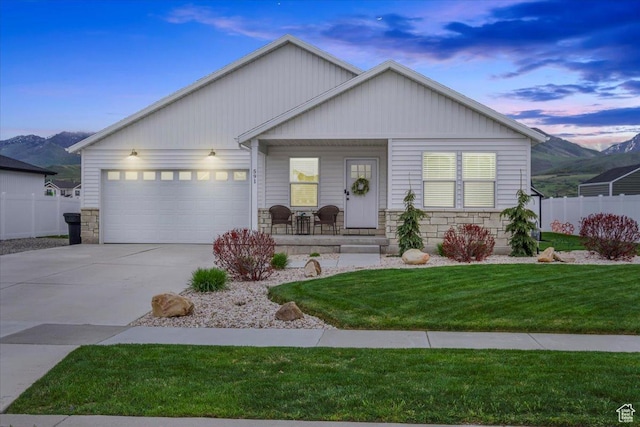 591 S Lakeside Dr, Franklin, ID 83237 - ranch-style house featuring fence, stone siding, a garage, concrete driveway, and covered porch