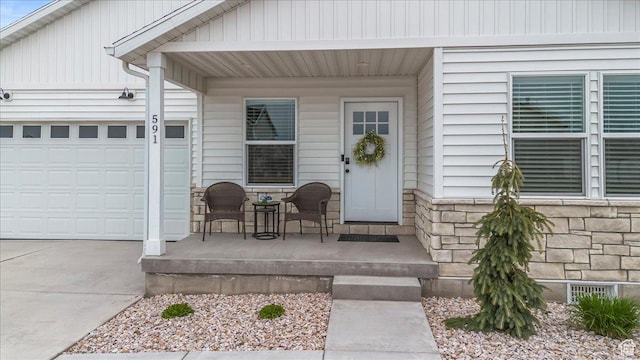 591 S Lakeside Dr, Franklin, ID 83237 - entrance to property featuring concrete driveway, an attached garage, covered porch, and stone siding