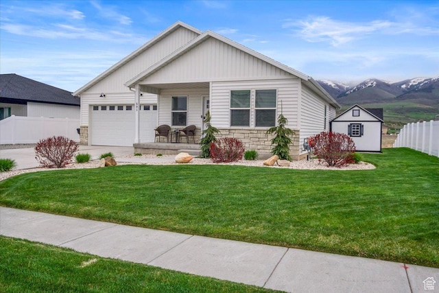 591 S Lakeside Dr, Franklin, ID 83237 - ranch-style home with a garage, a front lawn, fence, stone siding, and a porch