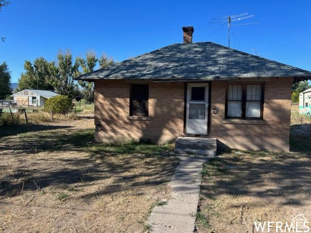 390 W Sandy Ln, Salina, UT 84654 - view of front of house featuring a shingled roof and a chimney
