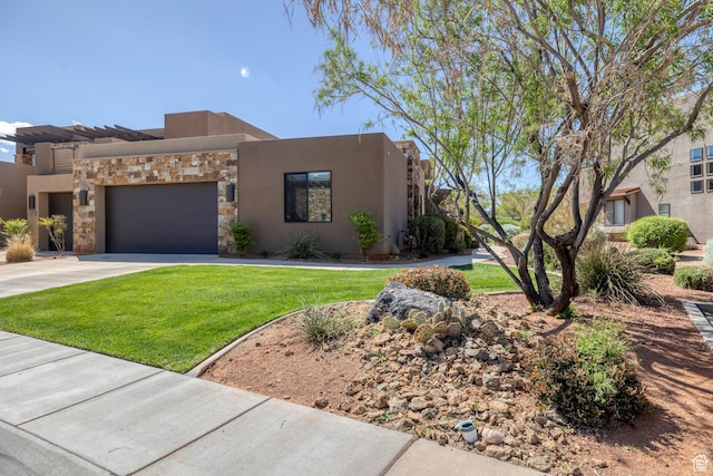 adobe home with stone siding, a garage, stucco siding, a front yard, and concrete driveway