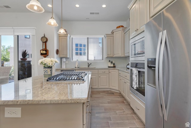 1677 W Escapes Dr Unit 103, St George, UT 84770 - kitchen with decorative backsplash, appliances with stainless steel finishes, a center island, a sink, and recessed lighting