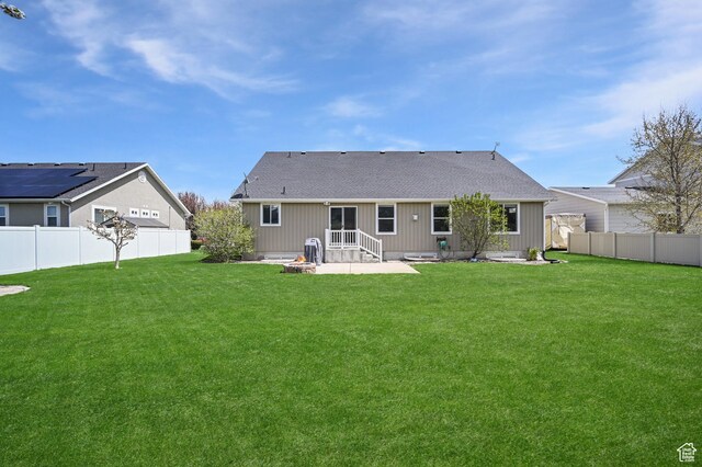 633 N 800 E, Wellsville, UT 84339 - back of house featuring roof with shingles, a lawn, a fenced backyard, an outdoor fire pit, and a patio