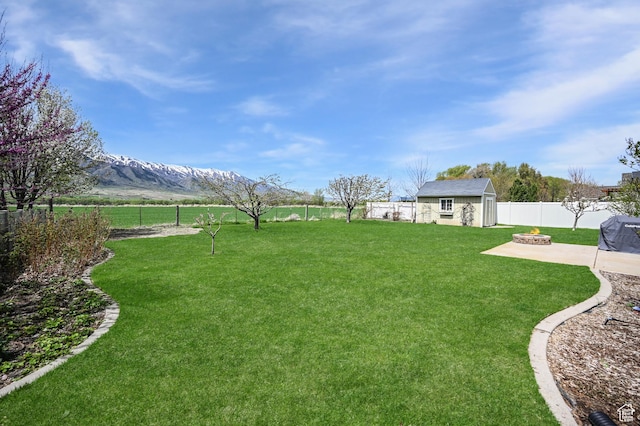 633 N 800 E, Wellsville, UT 84339 - view of yard with an outbuilding, a patio area, a mountain view, a fenced backyard, and an outdoor fire pit