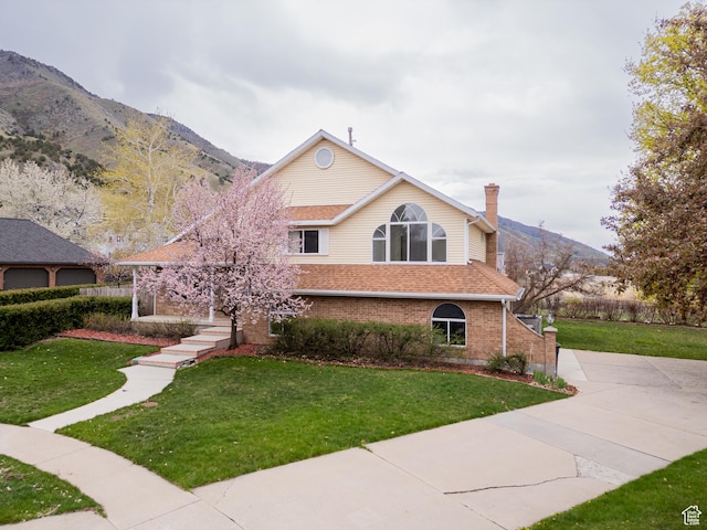 1720 N 1850 E, North Logan, UT 84341 - view of front facade featuring brick siding, a mountain view, and a front yard