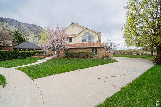 1720 N 1850 E, North Logan, UT 84341 - traditional-style home featuring brick siding, driveway, a mountain view, and a front lawn