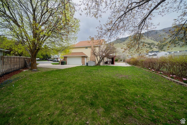 1720 N 1850 E, North Logan, UT 84341 - view of yard featuring concrete driveway, fence, a mountain view, and a garage