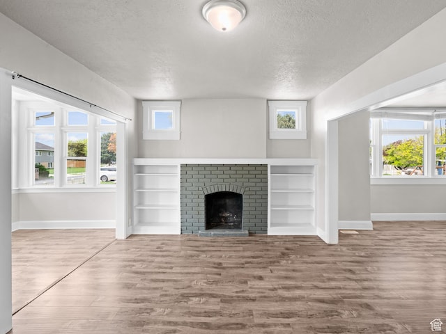 3084 W 3875 S, West Valley City, UT 84119 - unfurnished living room featuring baseboards, a textured ceiling, and wood finished floors