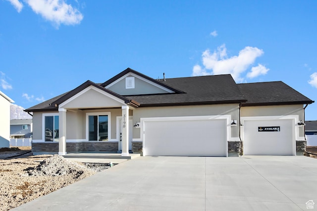 view of front of property with a garage, stucco siding, concrete driveway, and stone siding