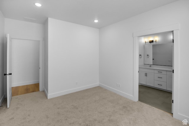 unfurnished bedroom featuring carpet floors, recessed lighting, baseboards, and ensuite bath