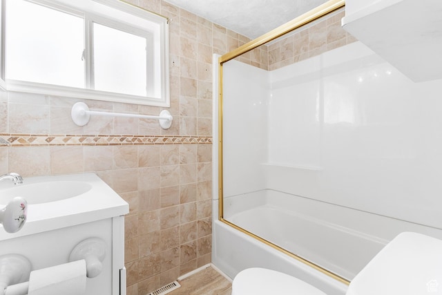 394 W 100 N, Mount Pleasant, UT 84647 - full bath with tile walls, bath / shower combo with glass door, toilet, and visible vents