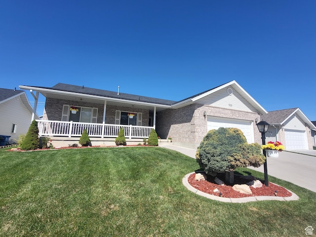 529 S 120 E, Smithfield, UT 84335 - ranch-style home with brick siding, a garage, a front lawn, and covered porch
