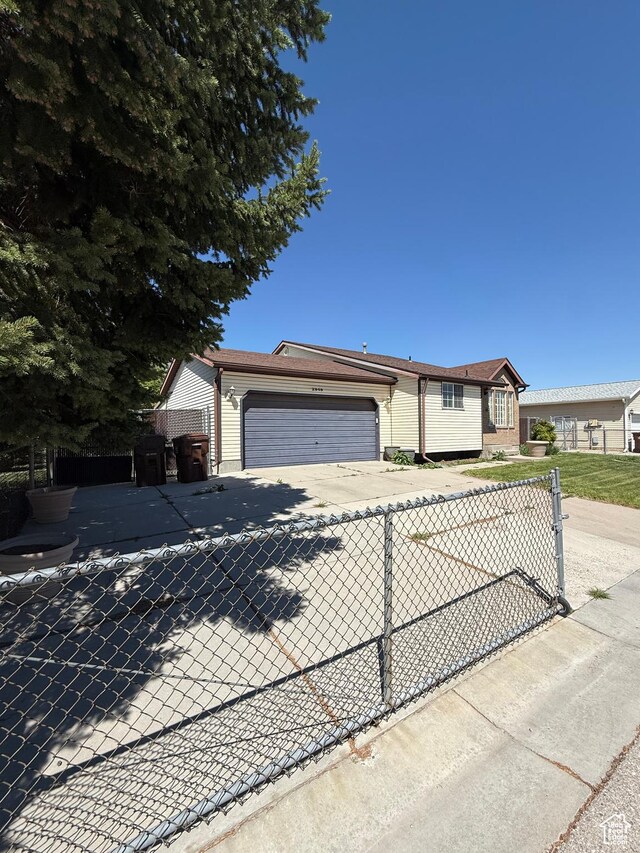 single story home with an attached garage, fence, and driveway