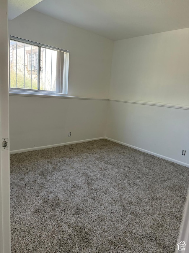 spare room with baseboards and carpet