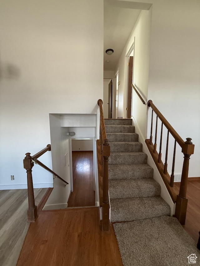 stairway featuring baseboards and wood finished floors