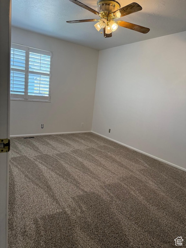 carpeted spare room featuring baseboards and ceiling fan