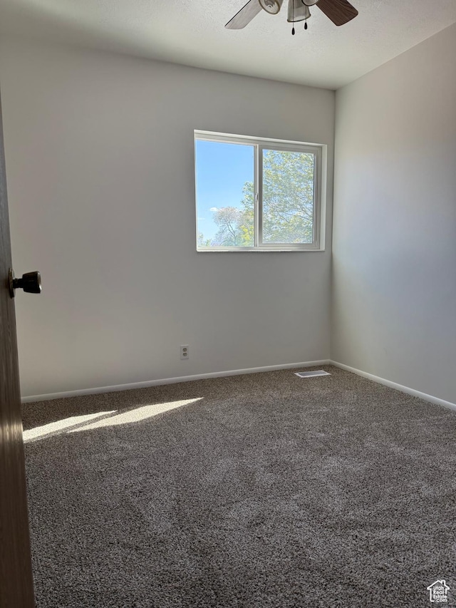 carpeted empty room featuring baseboards and ceiling fan