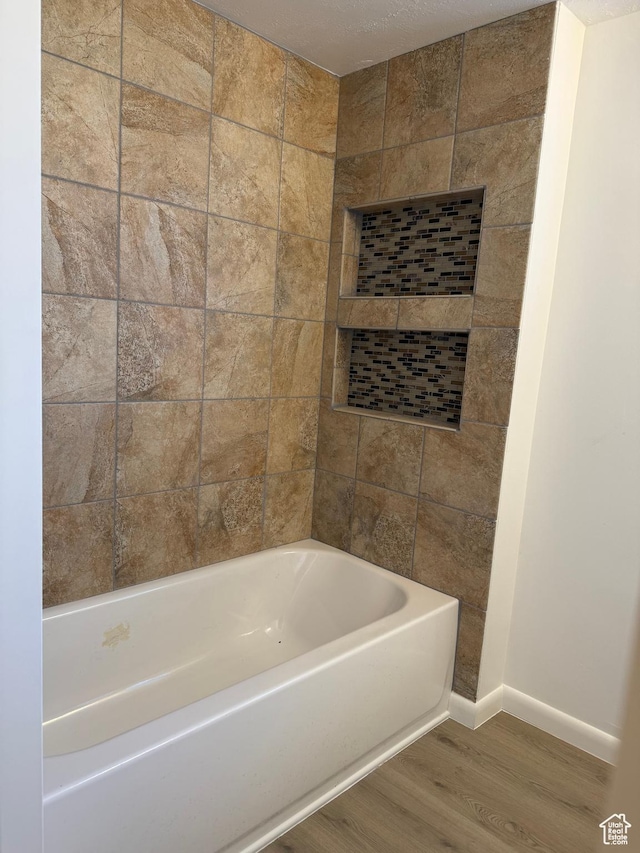 full bath featuring baseboards and wood finished floors