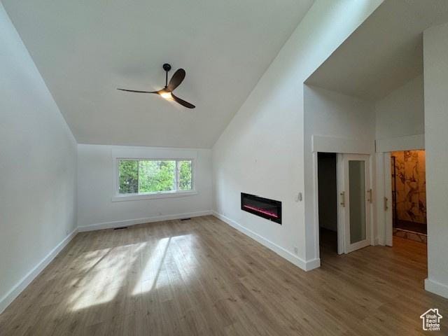 4758 S Ichabod St, Holladay, UT 84117 - additional living space featuring a glass covered fireplace, ceiling fan, wood finished floors, and vaulted ceiling