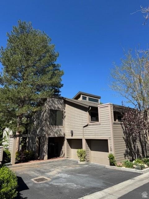 view of front of property featuring an attached garage and aphalt driveway